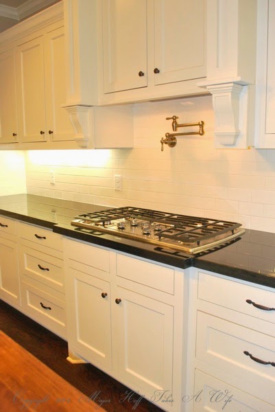 Traditional white kitchen stove area with water spout
