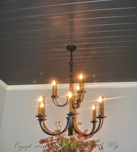 Dark grey planked ceiling with hanging traditional chandelier