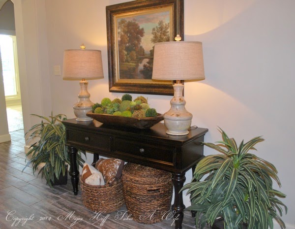 Entry way table with moss balls in french wooden dough bowl