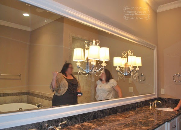 Long horizontal builder mirror framed with light fixtures on mirror