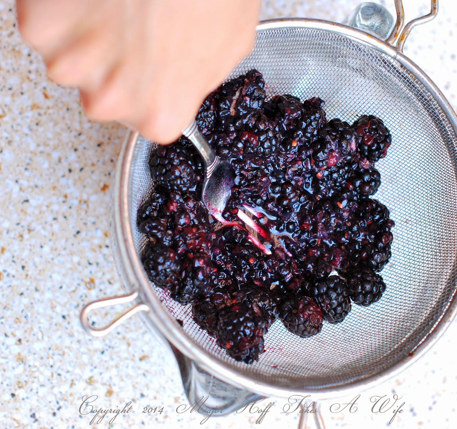juicing blackberries through a sieve juicing blackberries through a sieve