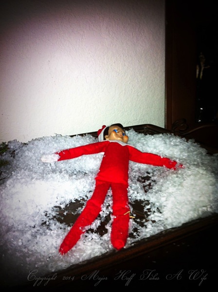 Elf on the shelf playing in snow
