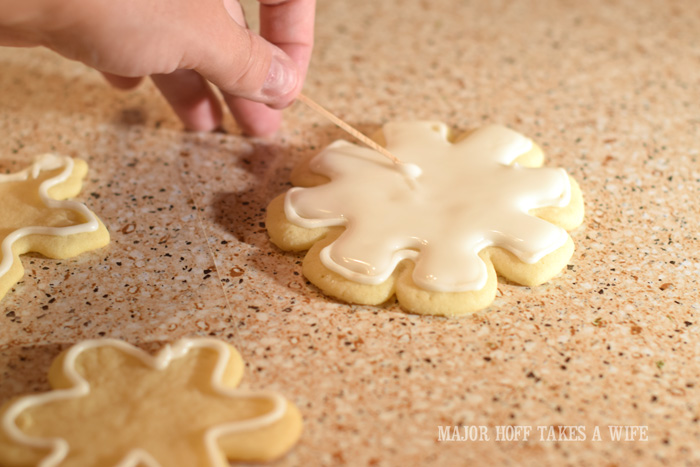 How to ice sugar cookies Using a toothpick to help flood cookies. 