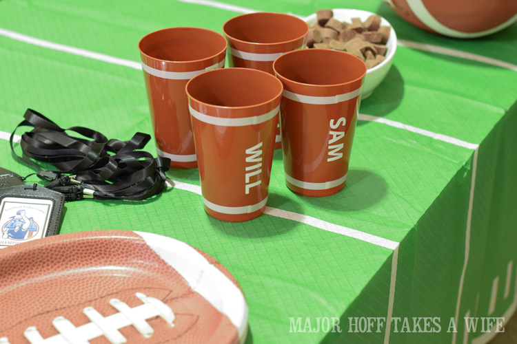 Personalized football cups. Looking for a fun party for your teenage boy? Why not throw a Football video game party? Easy ideas for how to entertain kiddos during the Big Game. Features DiGiorno pizza, personalized football cups, free printable lanyards, and an incredible recipe for football shaped ice cream sandwiches! #GameTimeMVP #CollectiveBias #ad
