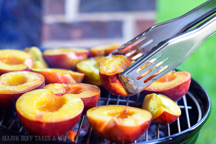 Use tongs to grill peaches on a charcoal grill