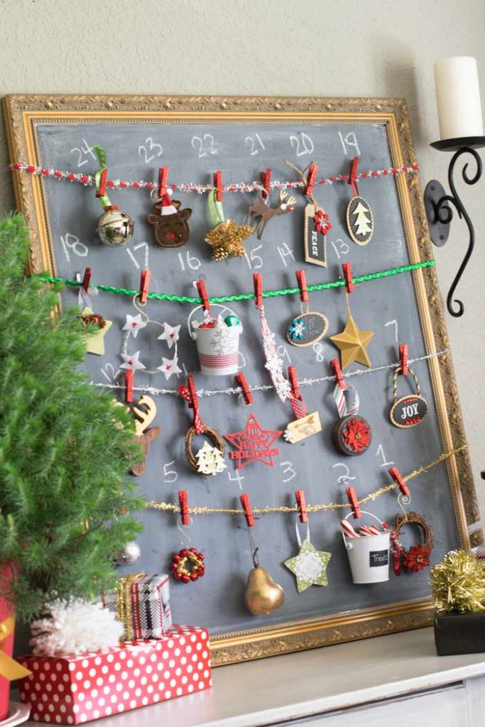 24 Christmas ornaments hang from a numbered chalkboard for a fun advent countdown.