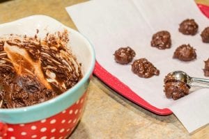 flourless peppermint chocolate cookie batter being scooped onto baking pan