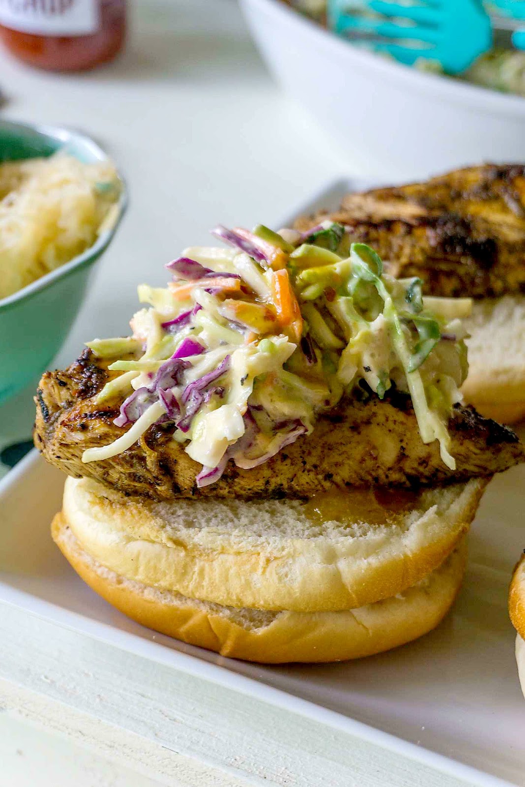 BBQ Heaven! Jerk Chicken Sandwiches with Mango Chipotle Coleslaw! Spicy grilled chicken breasts are topped with a crisp sweet and spicy coleslaw!