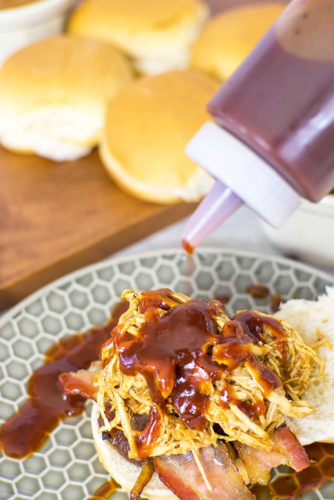 adding maple barbecue sauce to sliders made with pulled chicken breasts