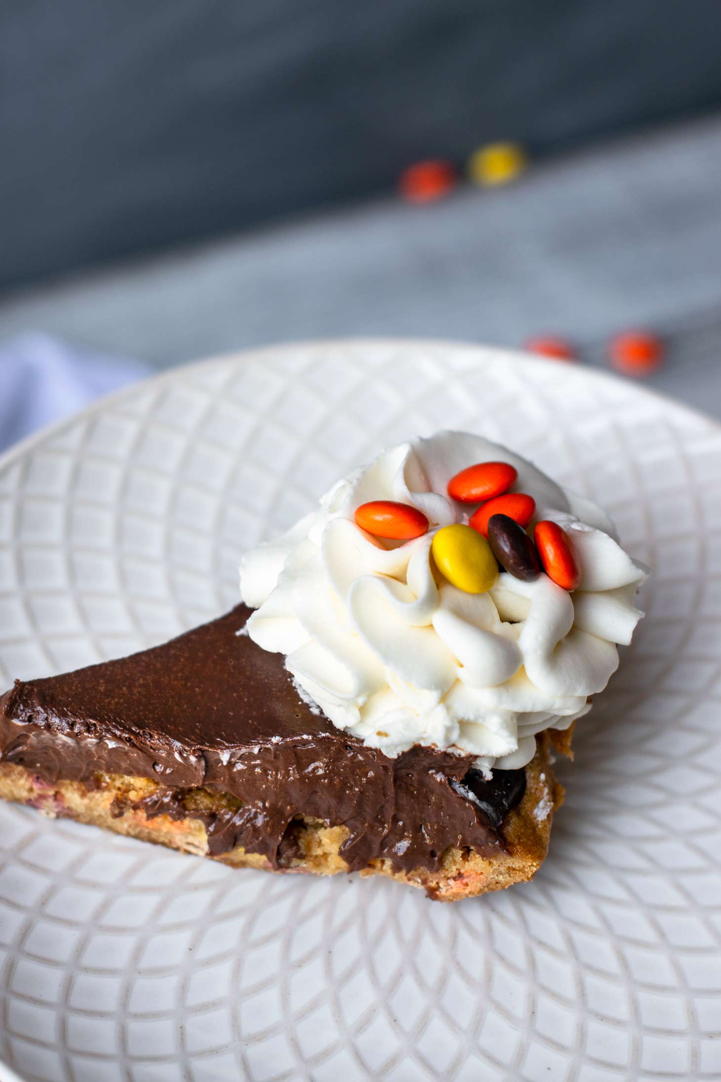 Peanut butter and chocolate pie on a white plate with Reese's pieces. 