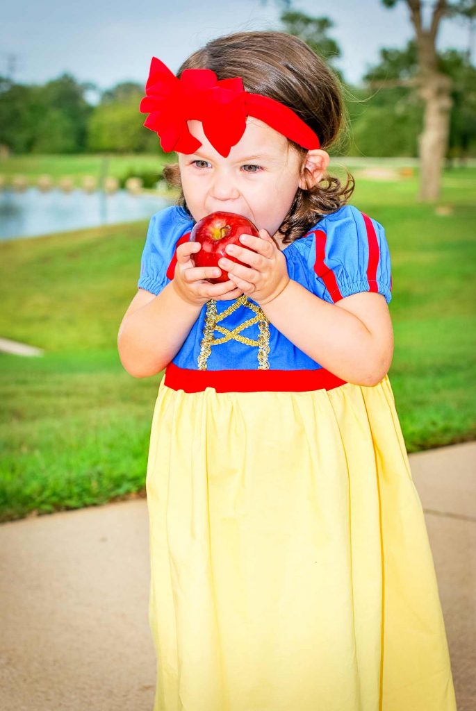 Red stripes on sleeves, gold ribbon on the bodice, and more details make this diy Snow White costume adorable on a toddler