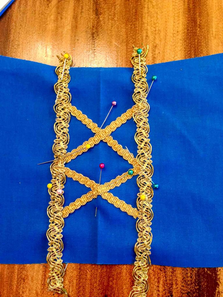 Up close view of gold ribbon detail on Snow White peasant dress bodice before sewing