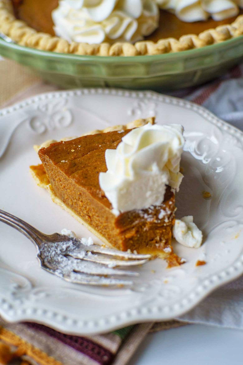 A simple pumpkin molasses pie topped with sturdy whipped cream frosting flowers