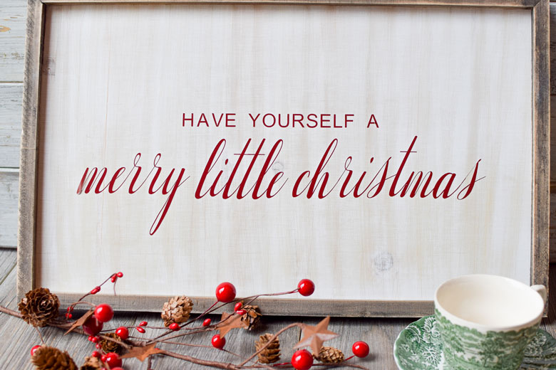 wooden whitewashed farmhouse sign with "have yourself a merry little christmas" in vinyl from an SVG file