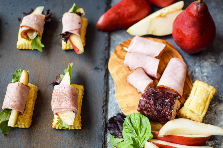serving goat cheese and meat roll ups on puff pastry on a slate serving board makes for an appealing way to serve appetizers