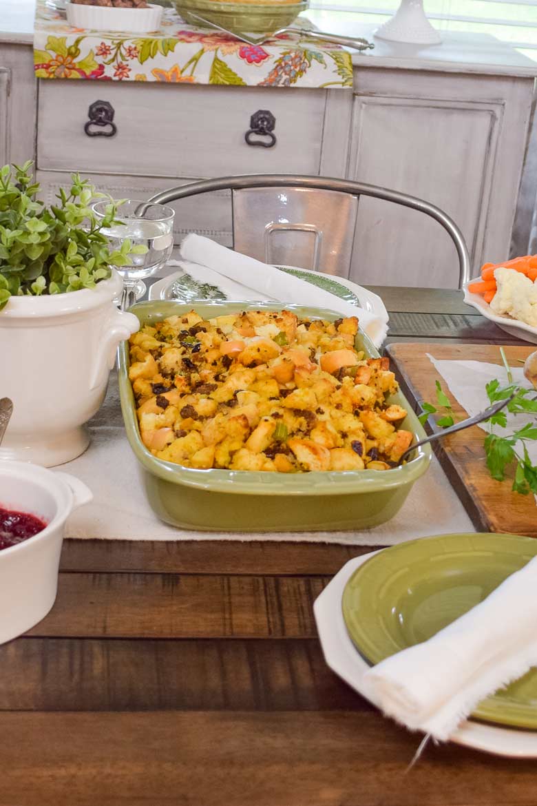Herb stuffing baked in a pretty green dish to go along side other Thanksgiving favorites like cranberry sauce