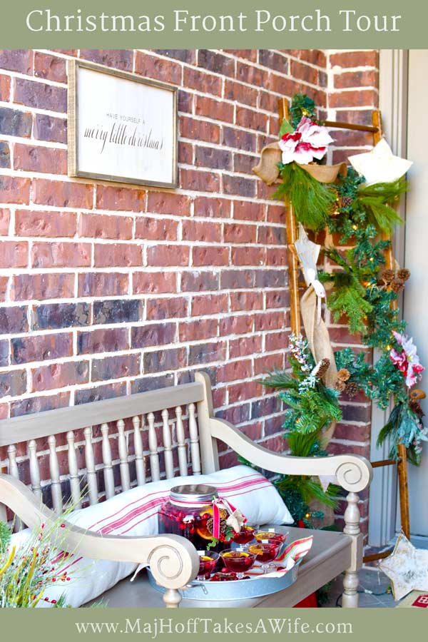 This Christmas porch is full of holiday cheer! Enjoy the farmhouse style decor and grab lots of ideas for a simple Christmas wreath, a ladder with lights and garland, a bench with an inviting drink, and lots of other DIY decorations. Be sure to check out all the details!