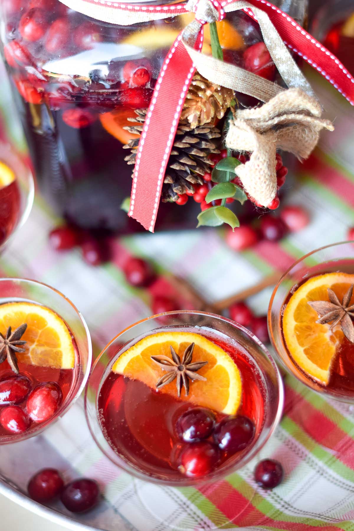Cranberry ginger ale punch in champagne glasses with oranges, cranberries and star anise