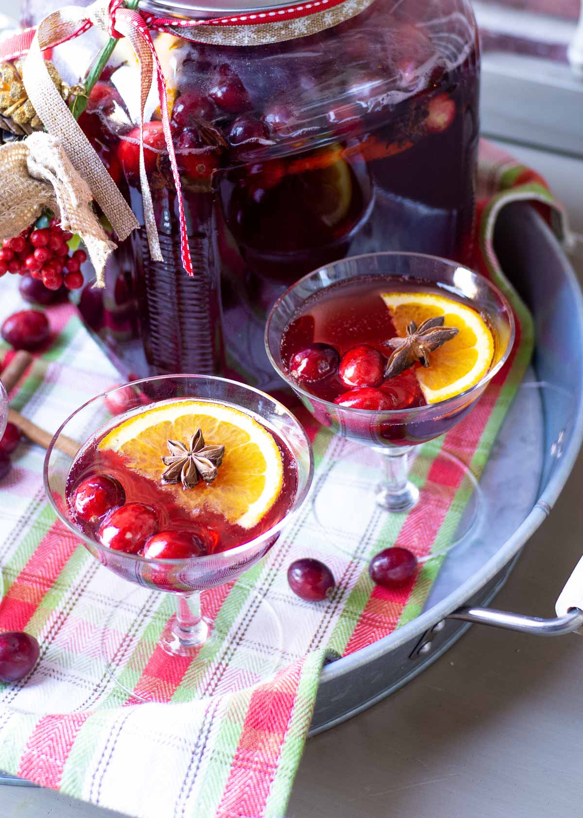 Garnish a cranberry cocktail with fresh cranberries, star anise and orange slices