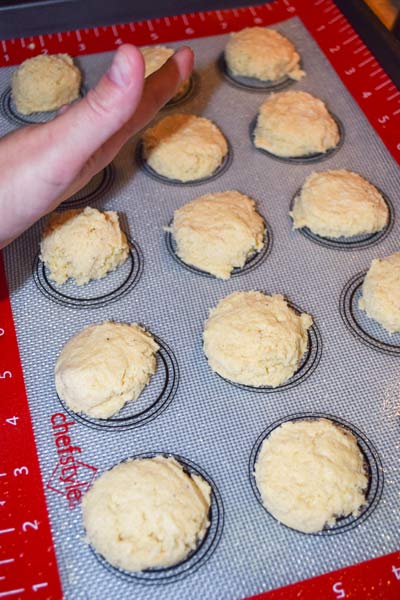 Sugar cookie dough being shaped on a non-stick baking mat