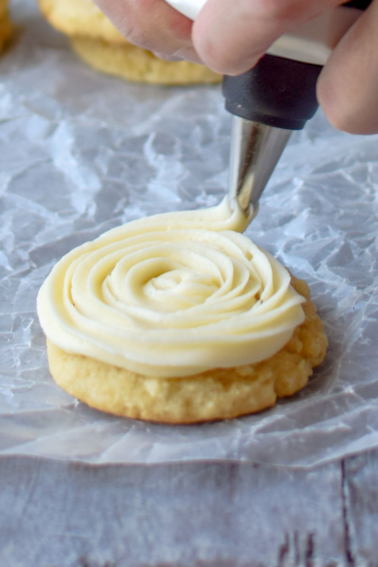 Use a slightly open star tip to ice buttercream icing onto an eggnog sugar cookie