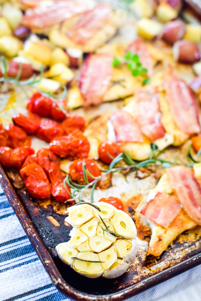baked garlic, tomatoes and chicken with bacon on a single sheet pan
