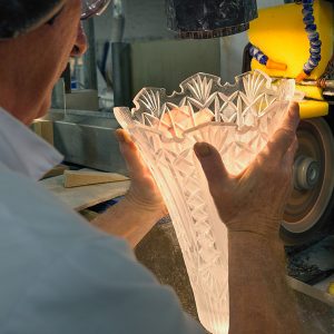 A master craftsman cutting glass on a diamond blade at Waterford Crystal Factory