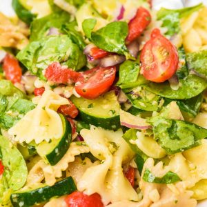 cold pasta salad with artichoke pesto sauce, zucchini, spinach, tomatoes and fresh summer veggies
