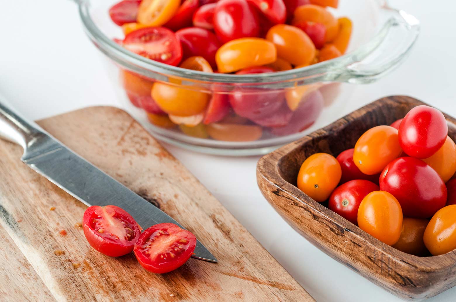 fresh cherry tomatoes being sliced for a homemade pasta sauce