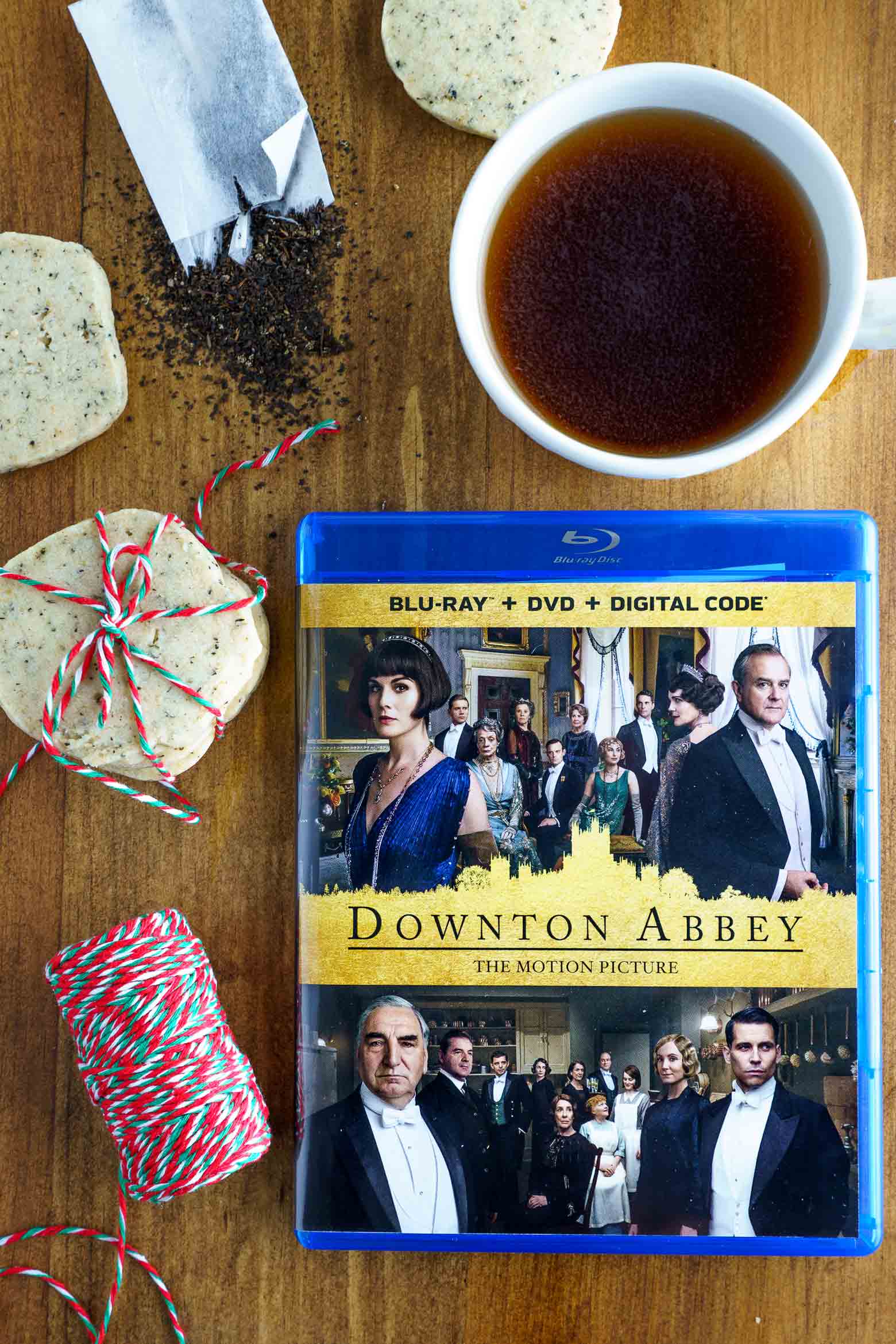 Downton Abbey DVD flat lay with teacup, loose tea and biscuits
