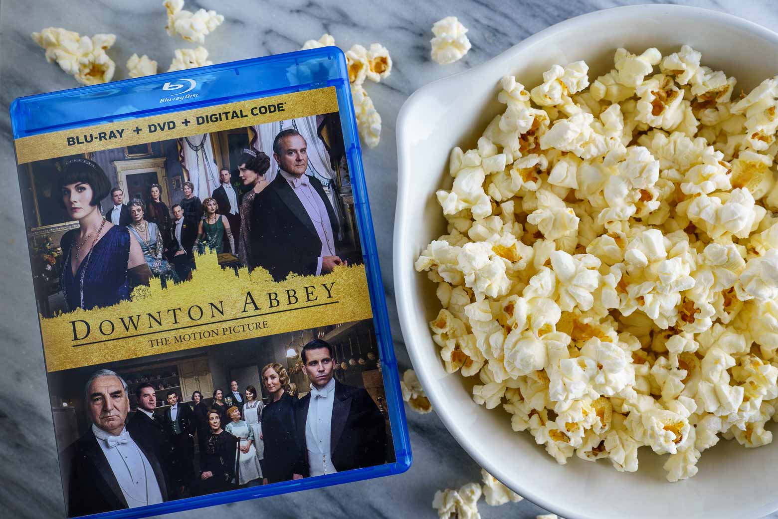 Downton Abbey Film DVD next to a bowl of popcorn