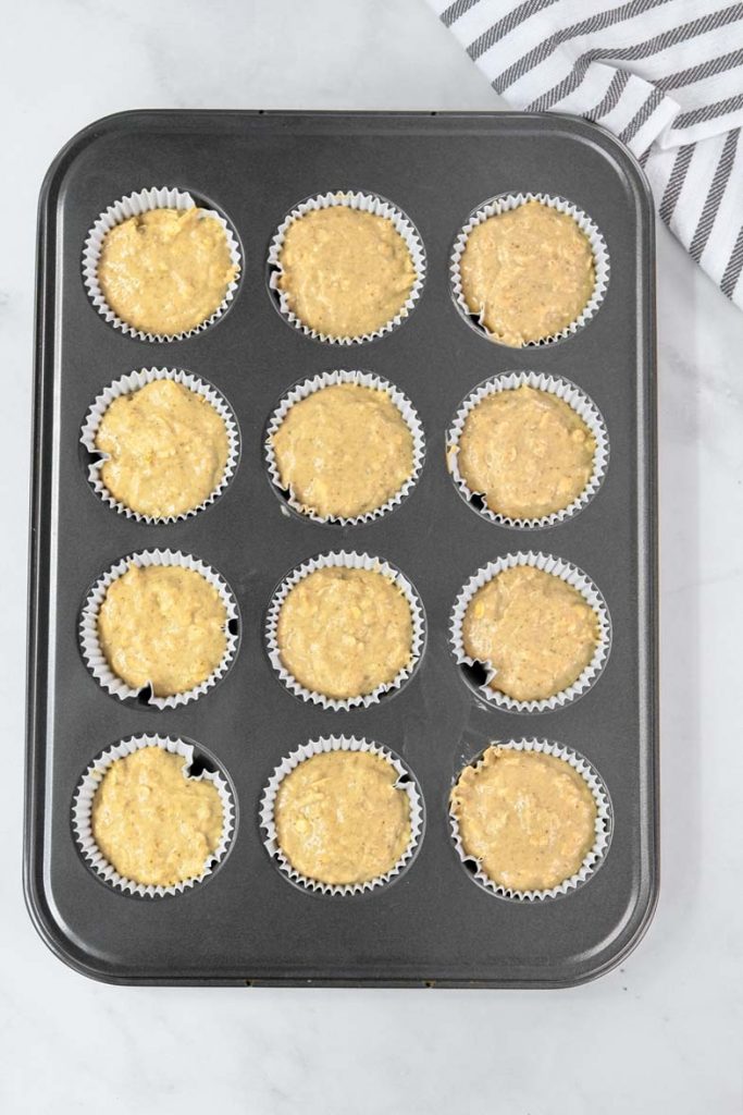 muffin batter in a gray muffin tin