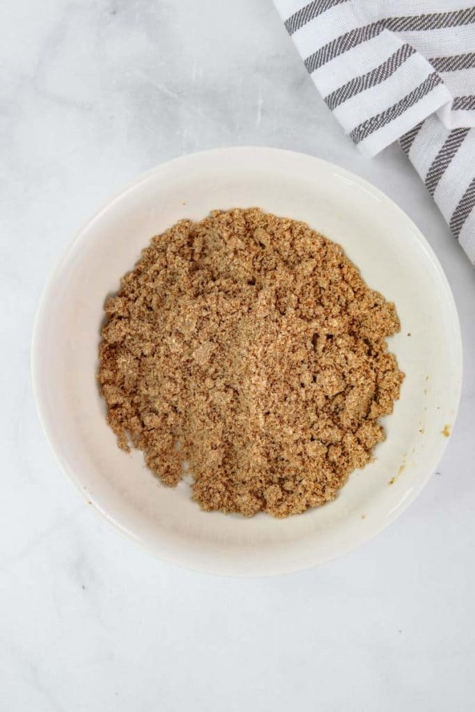 Basic streusel topping for a muffin in a white bowl on marble