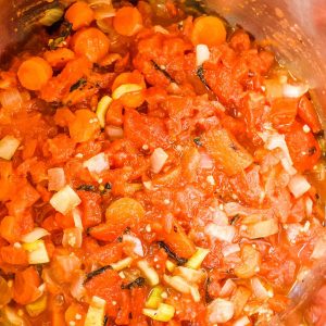 tomatoes carrots, onions, and celery in a pressure cooker pot