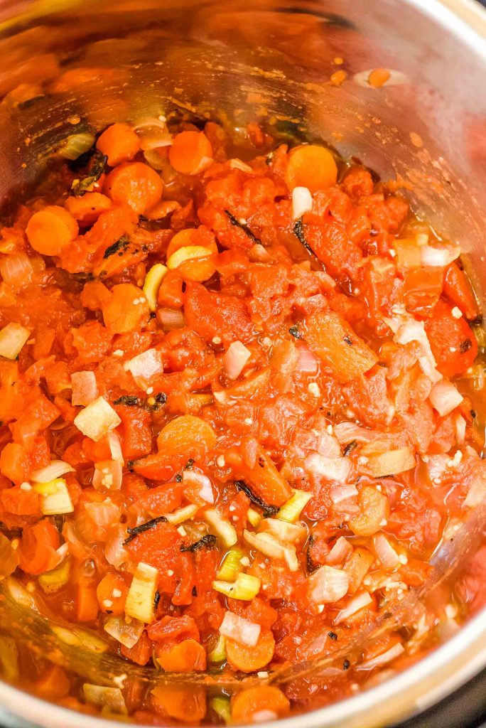 tomatoes carrots, onions, and celery in a pressure cooker pot