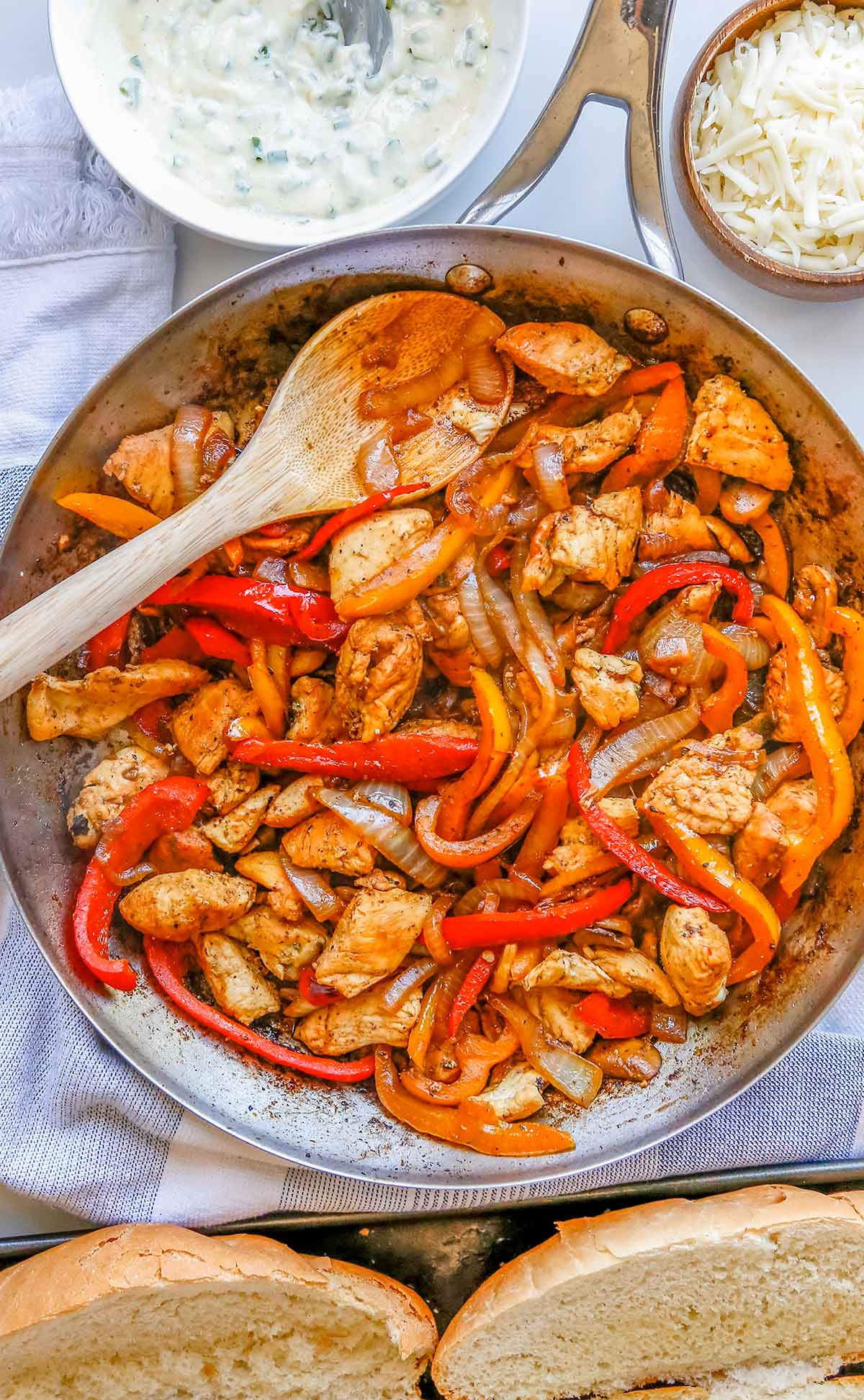 a skillet of cooked pieces of chicken breast  with peppers, onions, and mushrooms.