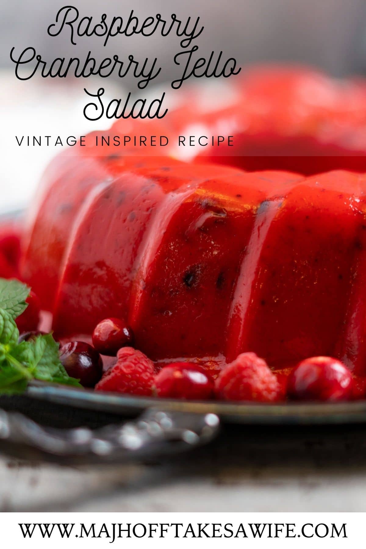 Classic raspberry cranberry jello salad is perfect to make for your holiday gatherings. It will take you 10-15 minutes to make, but the finished product is worth the short time investment. This vintage inspired recipe is made with just a few simple ingredients: cranberry jello, raspberry jello, whole berry cranberry sauce, vanilla ice cream, pink lemonade concentrate and frozen raspberries. There is not a touch of pineapple or mayonnaise in sight! Sure to become a holiday favorite! via @mrsmajorhoff