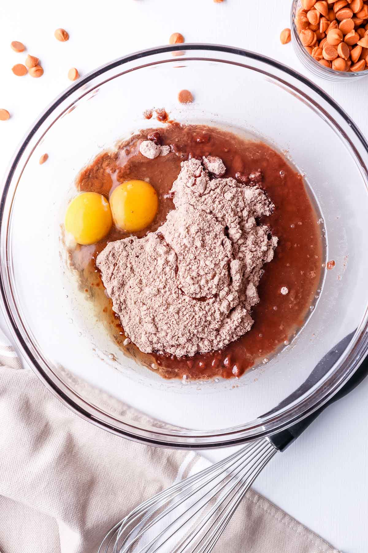 Cake mix, cocoa powder, oil and 2 eggs in a glass bowl.