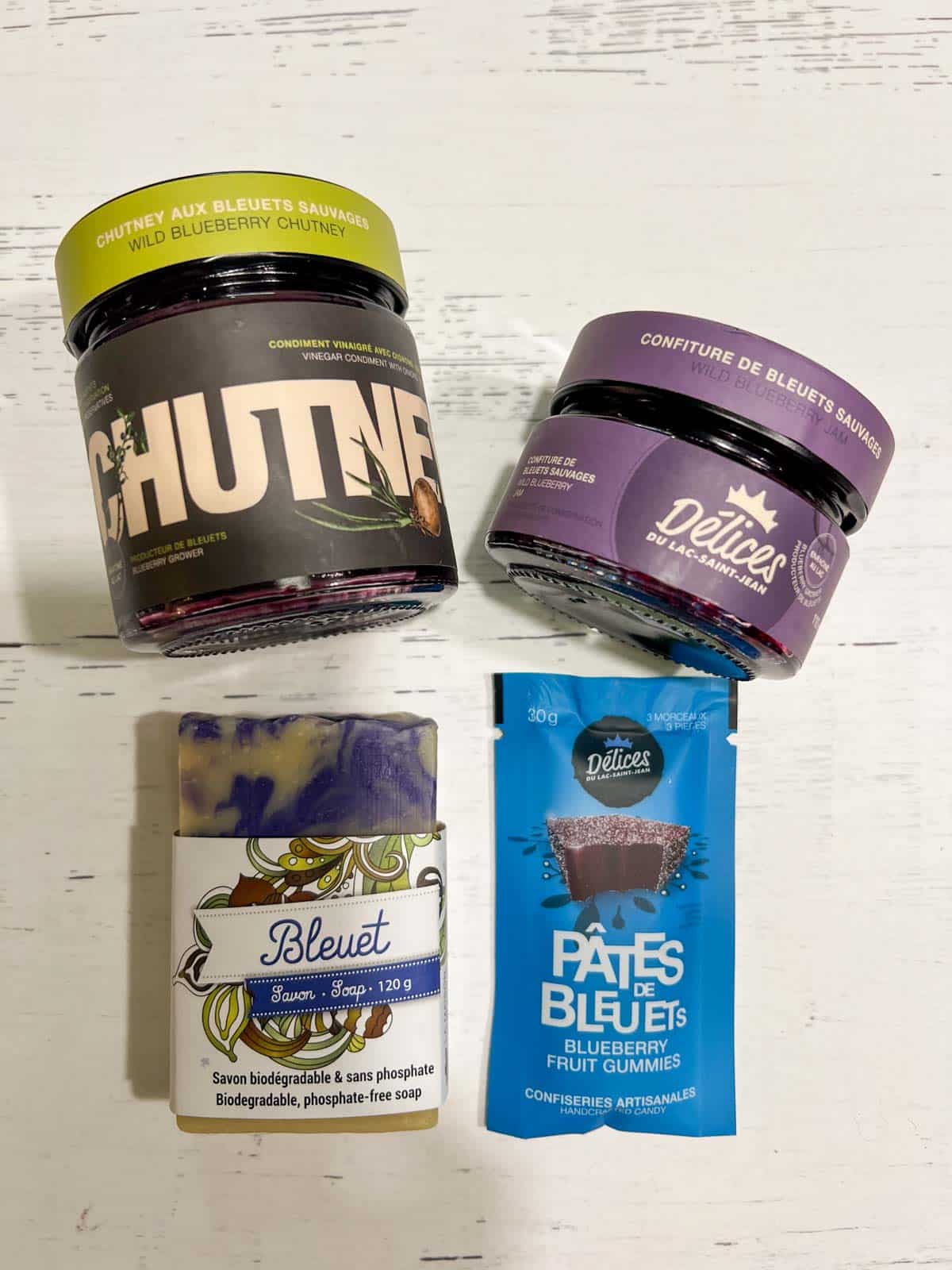 A jar of blueberry chutney, blueberry jam, a blueberry fruit bar and a bar of blue and white blueberry soap from Delices du Lac-Saint-Jean